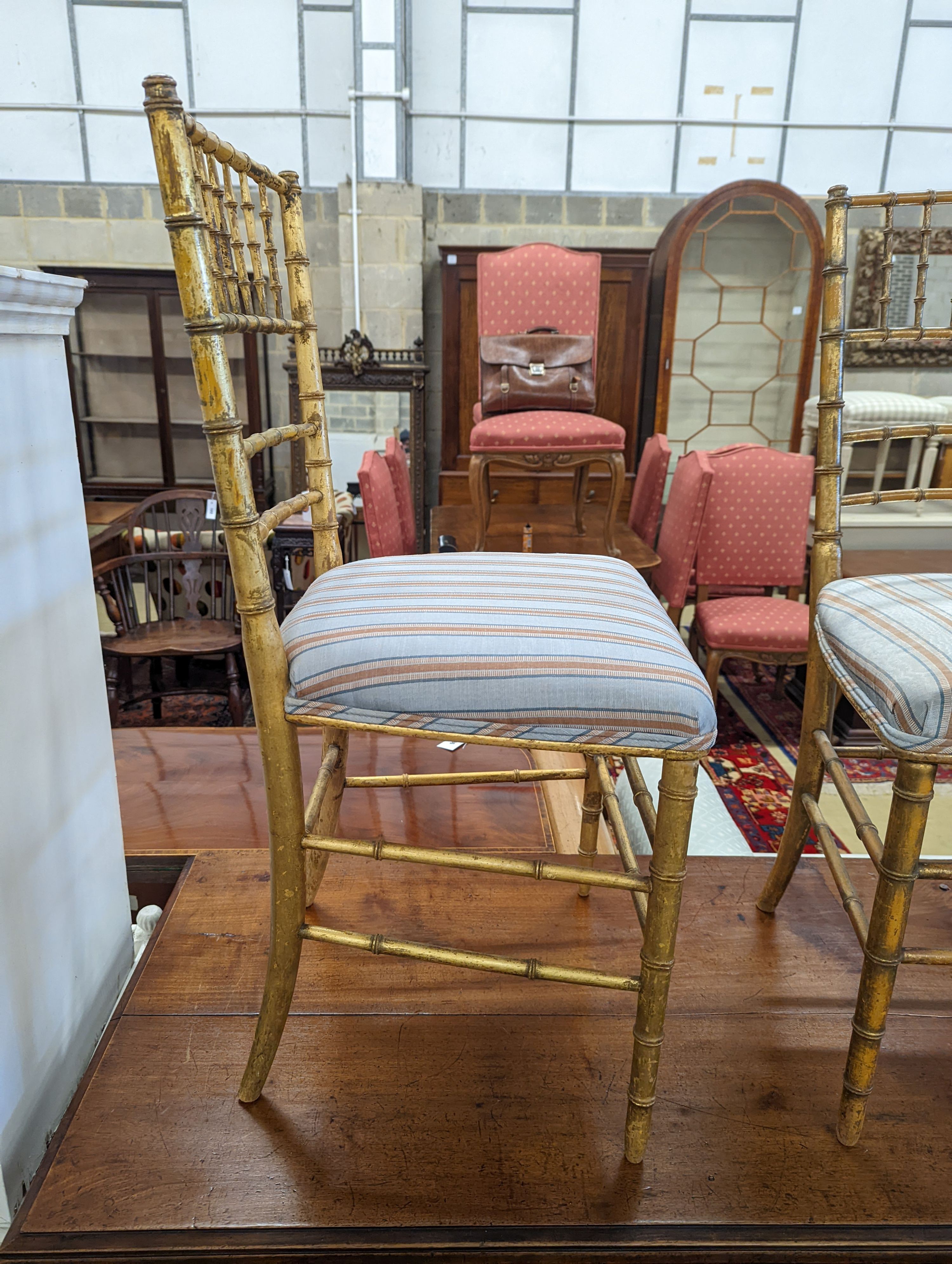 A pair of Regency simulated bamboo gilt wood side chairs with striped seats